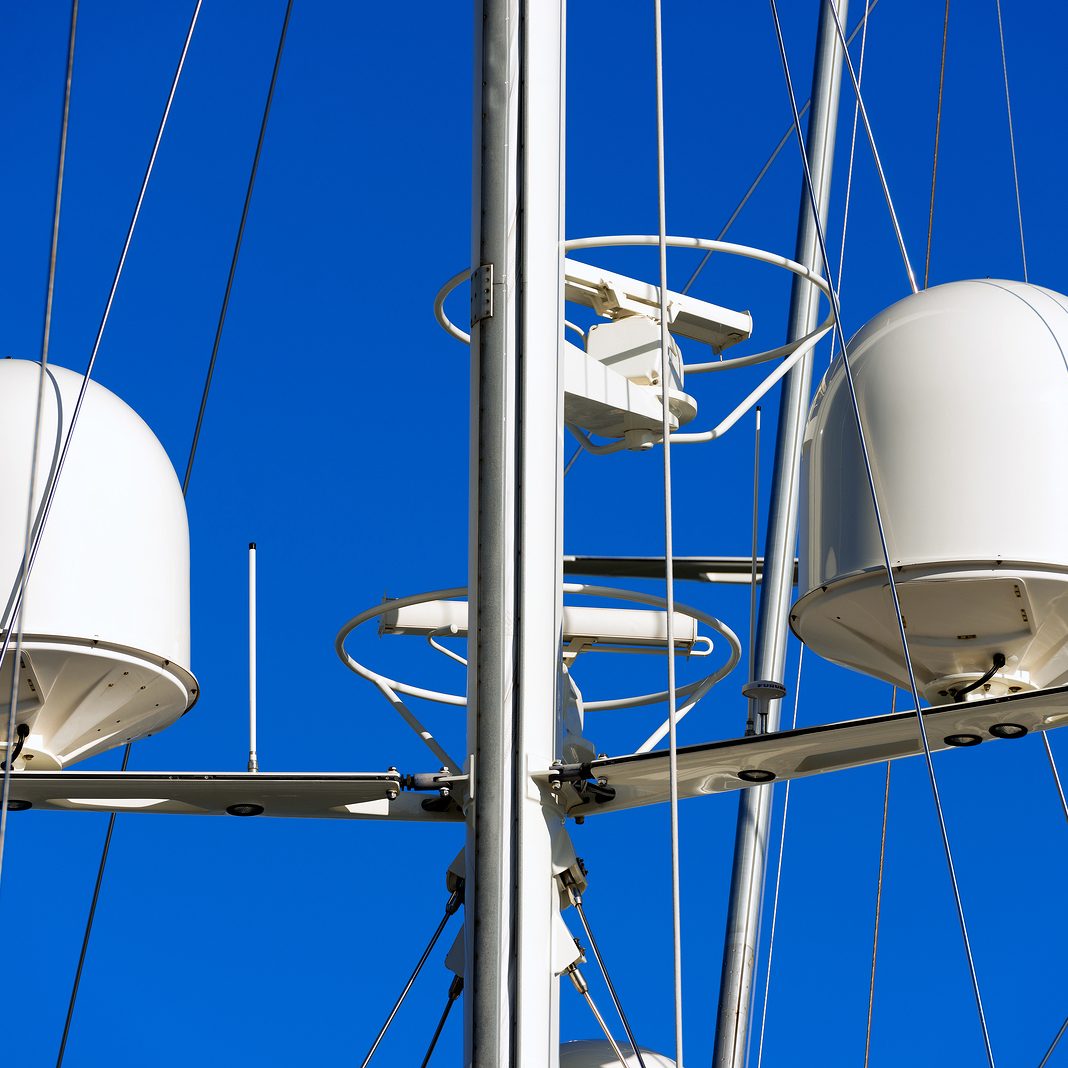 Detail of luxury white yacht with security camera and navigation equipment radar and antennas on blue sky